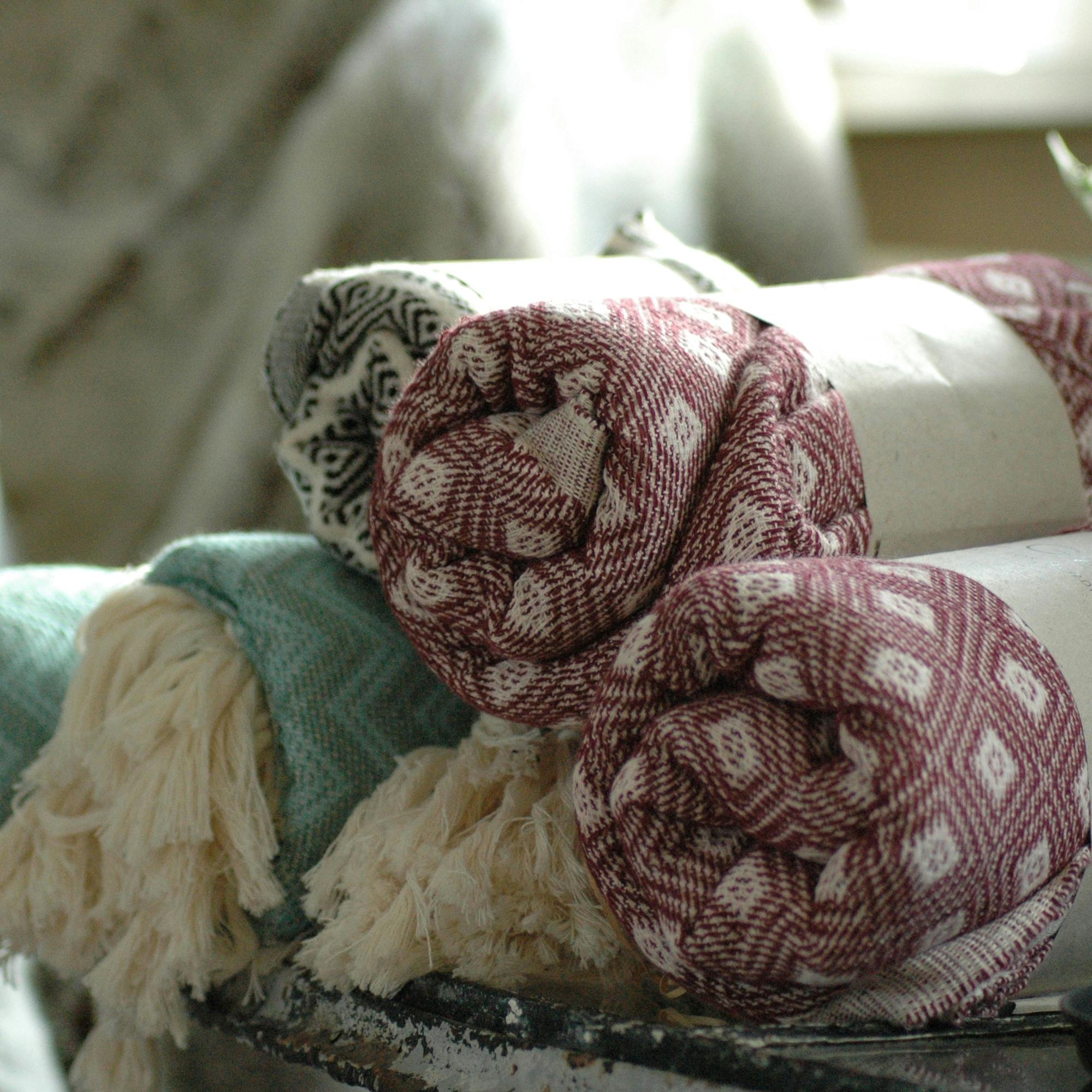Assorted rolled textiles in soft colors on display in Næstved, Denmark.